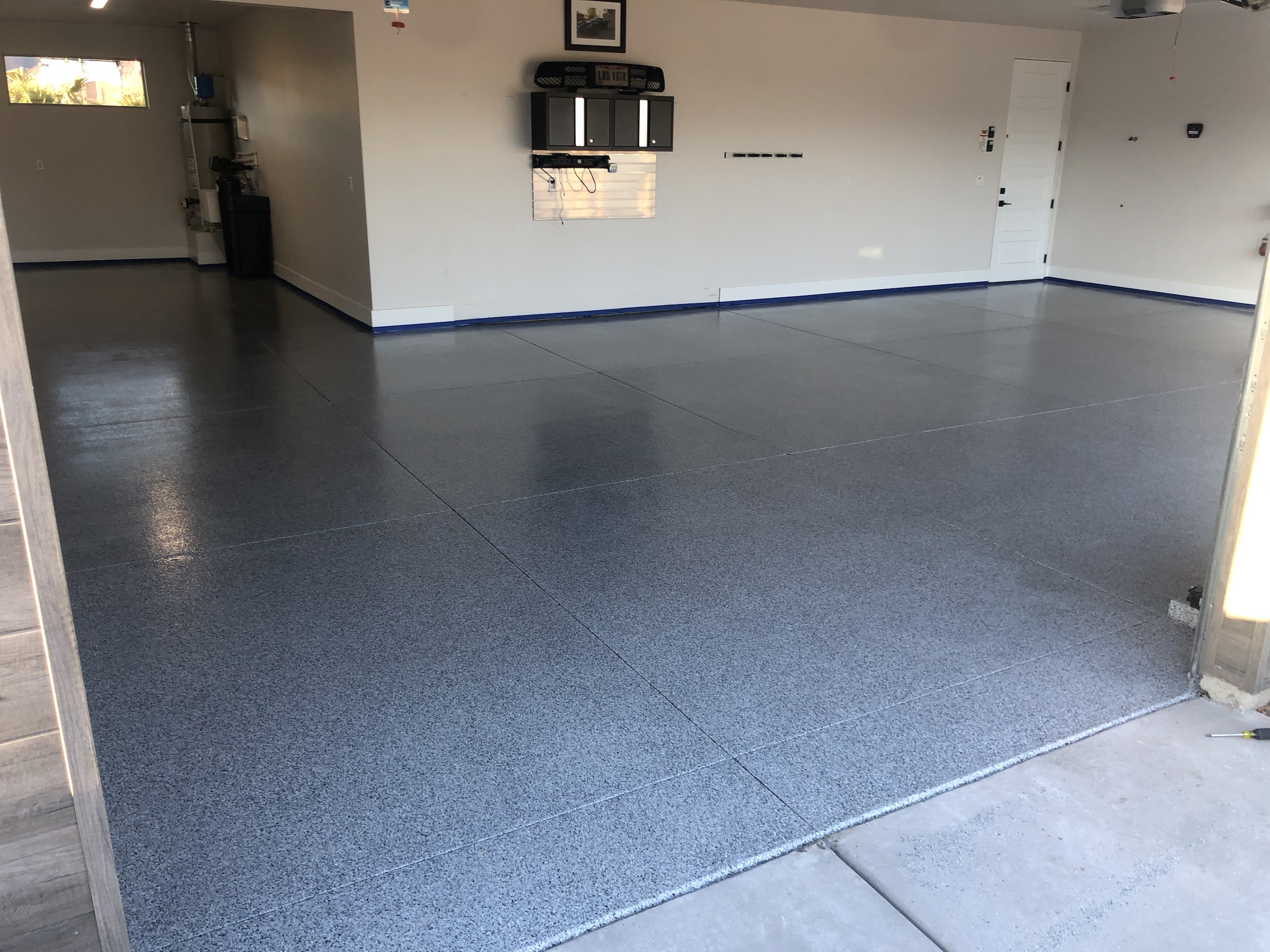 Finished Rezena Flake garage floor with a gray, white, black and blue decorative flake blend